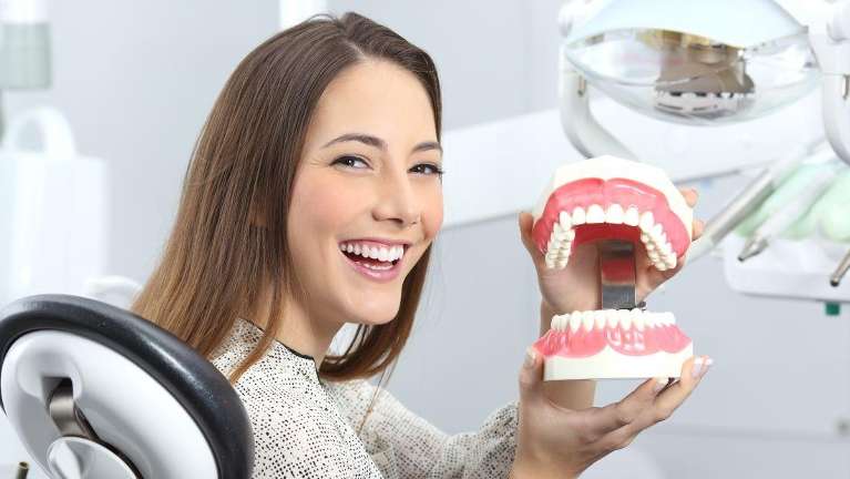Woman holding a teeth model